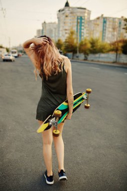 Güneşli havalarda longboard ile güzel dövmeli kız