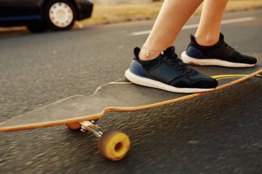 Güneşli havalarda longboard sürme dövmeli güzel genç kız
