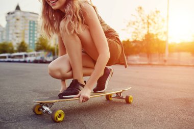 Güneşli havalarda longboard sürme dövmeli güzel genç kız