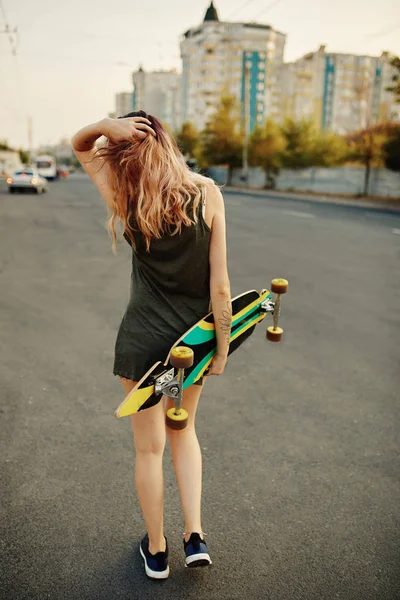 Piękna młoda dziewczyna tatuażem z longboard przy słonecznej pogodzie — Zdjęcie stockowe