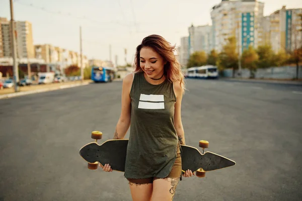 Hermosa chica tatuada joven con longboard en tiempo soleado — Foto de Stock