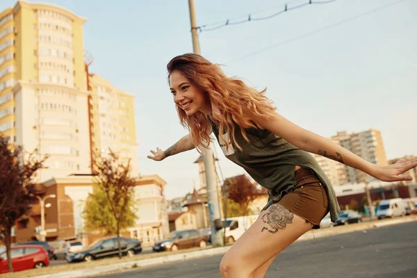 Mooi jong meisje met tatoeages longboard in zonnig weer Paardrijden — Stockfoto