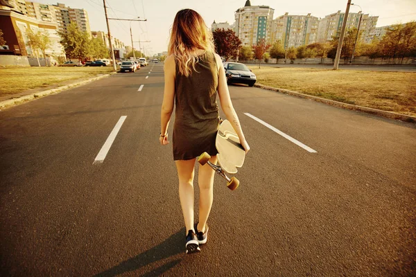 Schöne junge tätowierte Mädchen mit Longboard bei sonnigem Wetter — Stockfoto