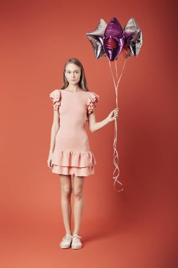 Kırmızı elbiseli balonlar tutan kadın.