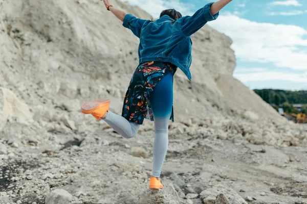 Junge Frau in bunten Kleidern posiert und tanzt — Stockfoto