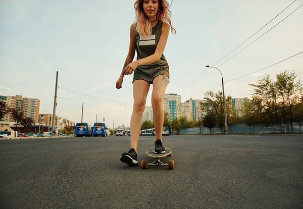 Mooi jong meisje met tatoeages longboard in zonnig weer Paardrijden — Stockfoto