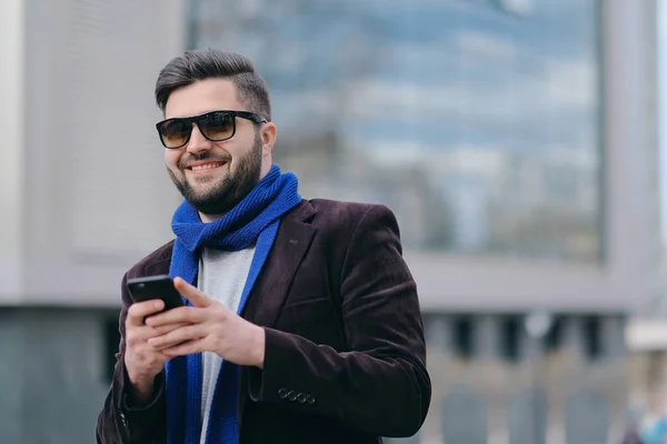 Молодой человек с мобильным телефоном на улице — стоковое фото