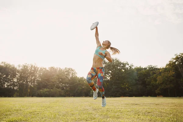 Disk, uçan ile oynayan genç atletik kız nihai — Stok fotoğraf