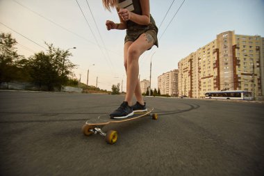 Güneşli havalarda longboard sürme dövmeli güzel genç kız