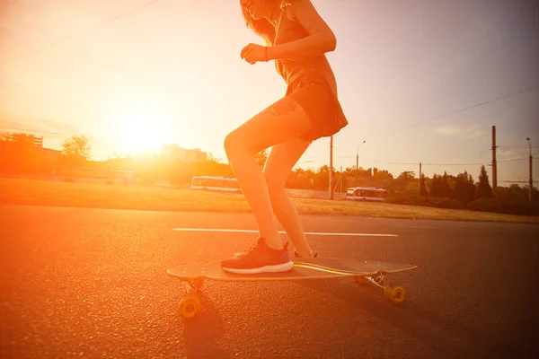 Hermosa chica joven con tatuajes montando longboard en tiempo soleado —  Fotos de Stock