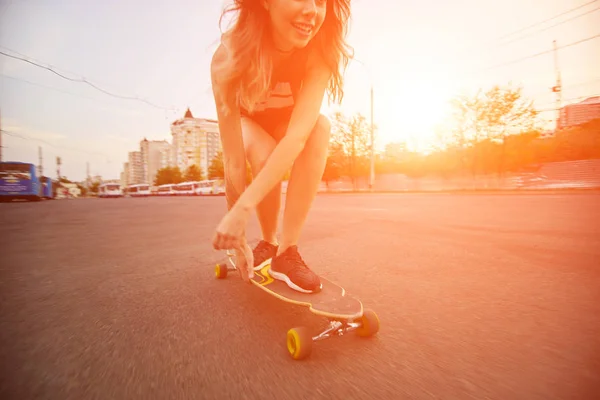 Όμορφη νεαρή κοπέλα με τατουάζ, ιππασία longboard στο ηλιόλουστο καιρό — Φωτογραφία Αρχείου