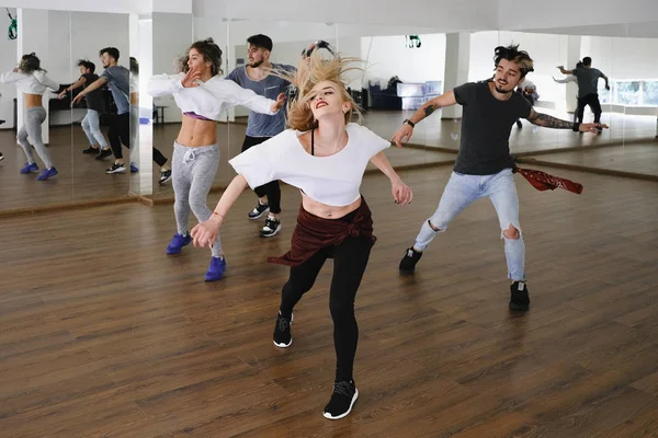 Gruppo di giovani ballerini moderni che ballano in studio — Foto Stock