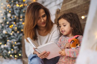 Anne ve kızı Noel arifesinde okuma