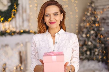 Mutlu kadın bir hediye kutusu tutuyor.