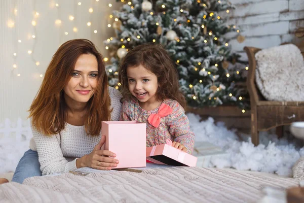 Happy mom with kid looking to camera while holding Christmas gif