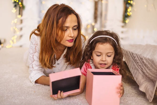 Gelukkig moeder met kind op zoek binnenkant van de doos van de gift van Kerstmis — Stockfoto