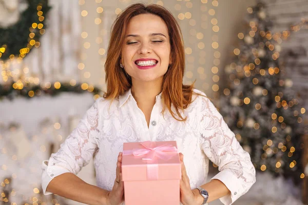 Happy beautiful young woman holding a gift box — Stock Photo, Image