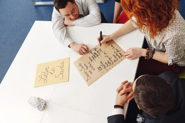 Equipo emocionado está escribiendo una carta a Santa mientras sonríe — Foto de Stock