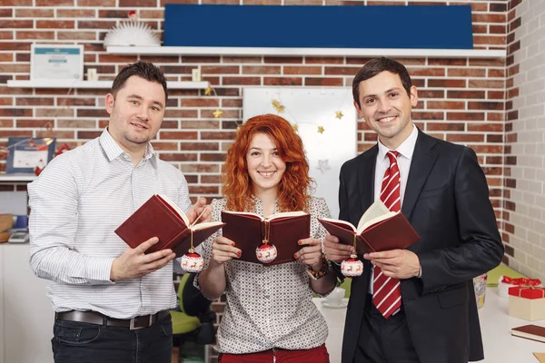 Three people holding books in hands — Stock Photo, Image