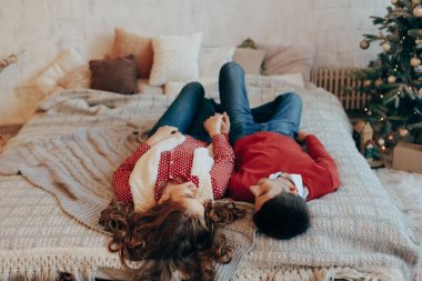 Genç çift başkanları ile baş aşağı gülümseyen yatakta döşeme