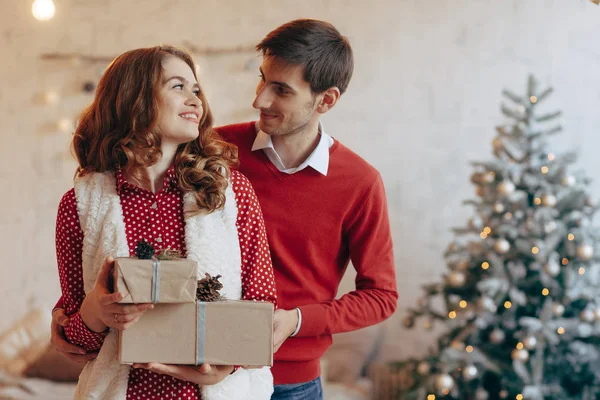 Noel ile mutlu genç çift sunar — Stok fotoğraf