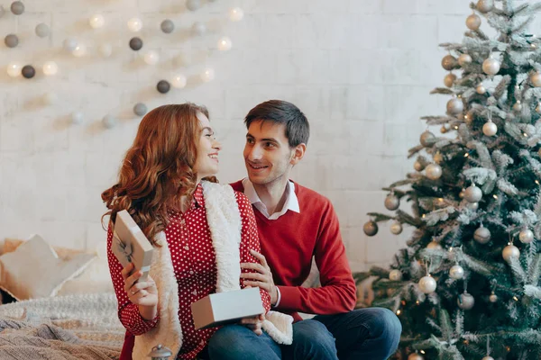 Adorable pareja abriendo regalos de Navidad sonriendo — Foto de Stock