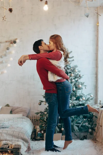 Sarılma ve öpüşme Noel boyunca genç çift gösteren resim