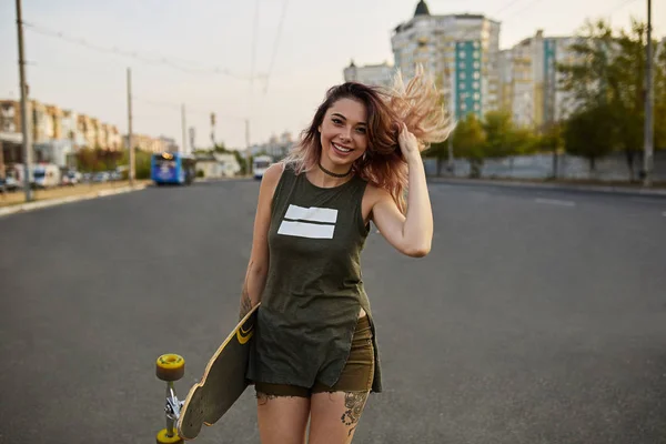 Dövmeler ile renkli bir longboard poz ile güzel kız — Stok fotoğraf