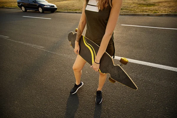 Menina mãos segurando um longboard — Fotografia de Stock