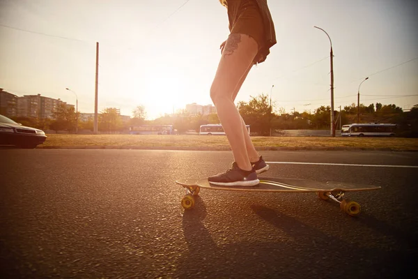 Hipster met tatoeages skateboarden in de stad — Stockfoto