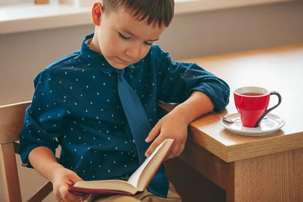 Lezing jongen met kopje thee — Stockfoto