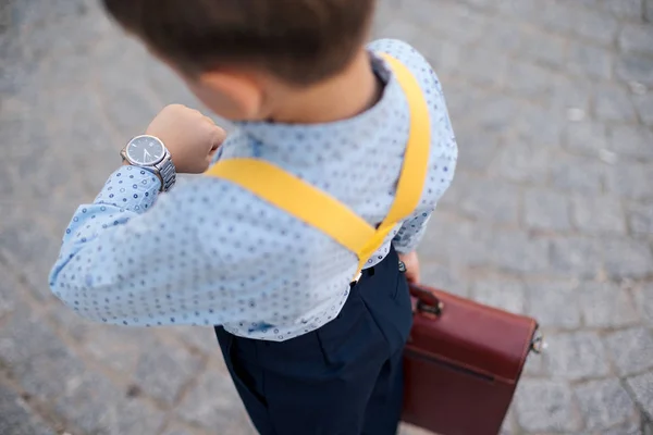 Boy verifying time on his silver watch on his hand — Stock Photo, Image