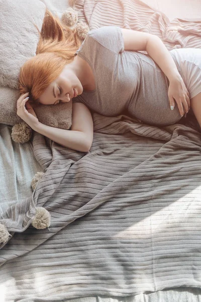 휴식 하는 침대에 누워 아름 다운 임신한 여자 — 스톡 사진