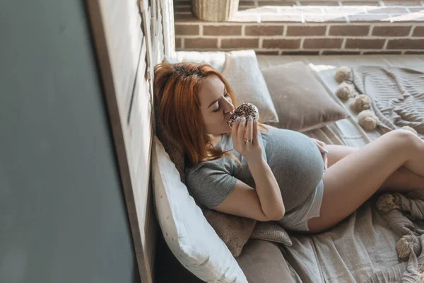 Zwangere vrouw eten van heerlijke donuts — Stockfoto