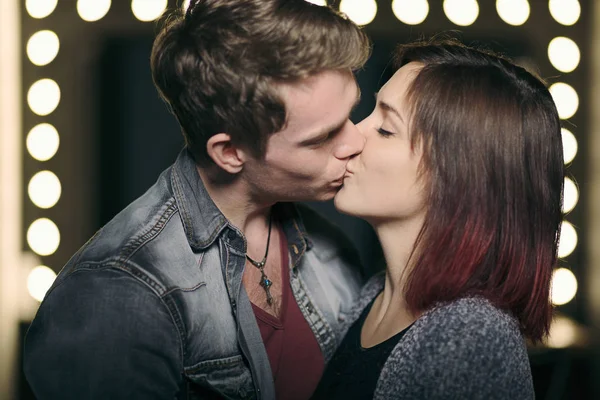 Casal bonito beijando com luzes no fundo — Fotografia de Stock