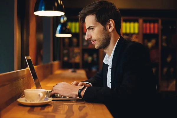 El hombre seguro de trabajar en el ordenador portátil que tiene café — Foto de Stock