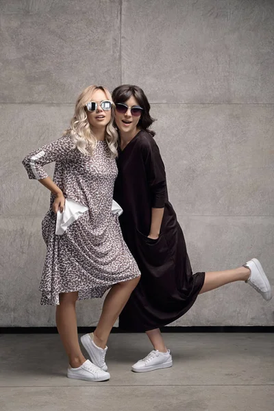 Две весёлые модные девушки в солнечных очках — стоковое фото