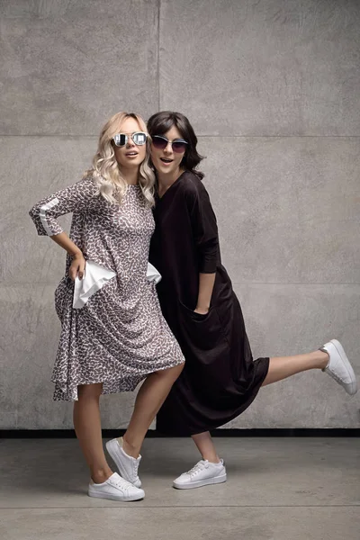 Deux joyeux jeunes femmes branchées portant des lunettes de soleil — Photo