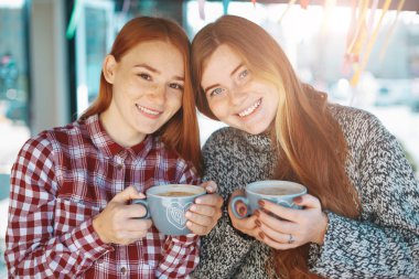 Gülümseyen güzel genç kadın kahve ile poz