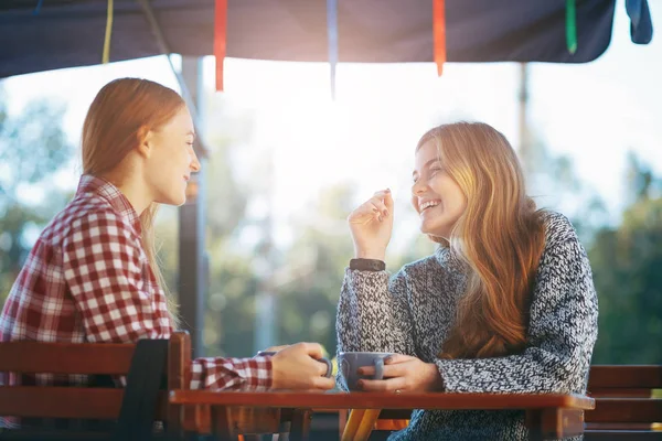 Sonrientes mujeres jóvenes tomando café — Foto de Stock