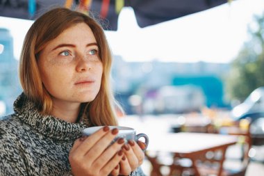 Büyük bir fincan kahve tutan kırmızımsı doğal kız Close-Up