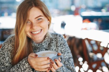 Büyük bir fincan kahve sho tutarak doğal kırmızımsı kız Close-Up