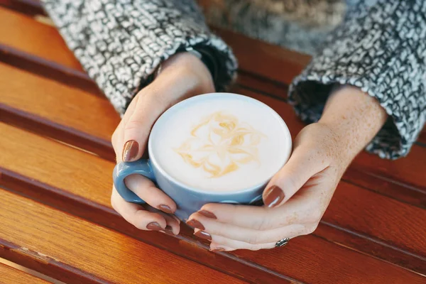Ręce, trzymając kubek z gorącą latte biały — Zdjęcie stockowe