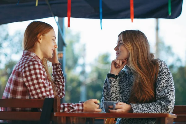 Sonrientes mujeres jóvenes tomando café — Foto de Stock