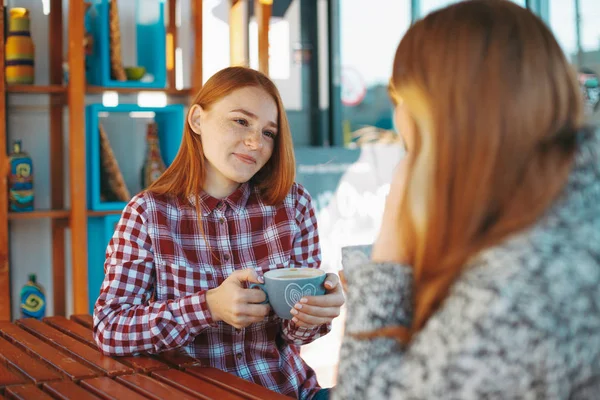 Sonrientes mujeres jóvenes tomando café — Foto de Stock