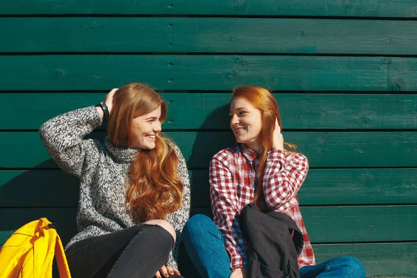 Usmívající se dívky chating a hrát si s vlasy — Stock fotografie