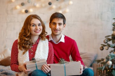 Noel hediyeleri olan mutlu genç bir çift.
