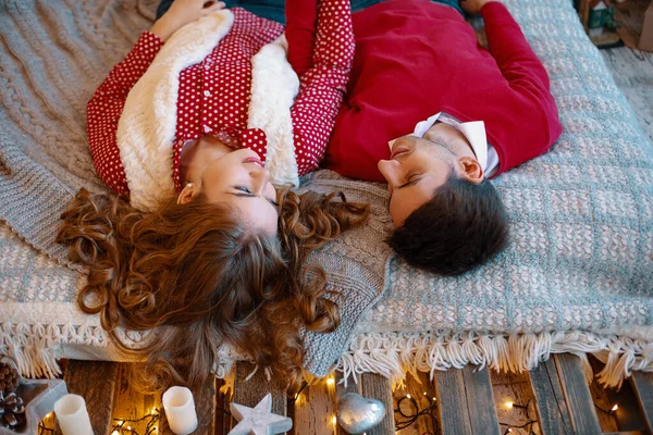 Jeune couple attrayant se couche sur le lit, regardant à l'autre passer du temps ensemble. Vue de dessus. Jeune couple allongé sur le lit souriant avec les têtes à l'envers . — Photo