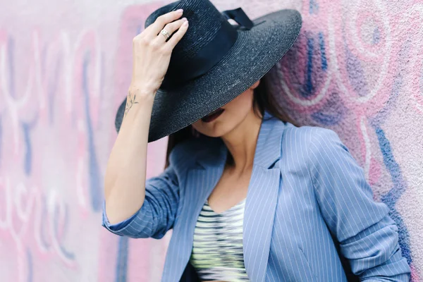 Modeporträt eines jungen Mädchens in blau gestreifter Jacke und schwarzem Hut — Stockfoto