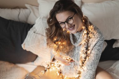 Müstakbel anne, doğmamış çocuğuna evde yatarken kıyafetlerini ışıkla süsleyerek pozitif titreşimler gönderiyor.